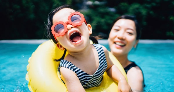 Mom and daughter swimming in pool