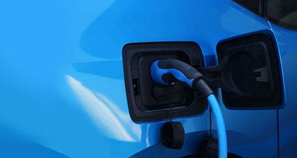 EV charger plugged into electric blue car