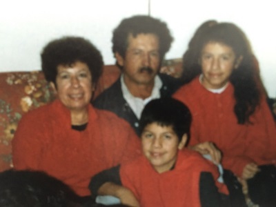 Noemi's family celebrating Christmas in the late 80's with coordinated outfits.