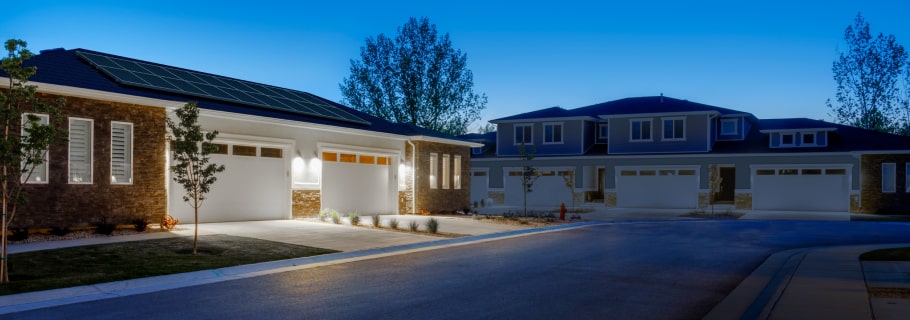 house with lights on in neighborhood experiencing power outage