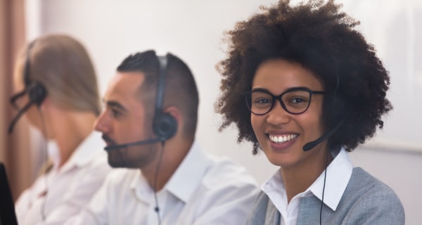 image of 3 customer service reps on the computer and phones