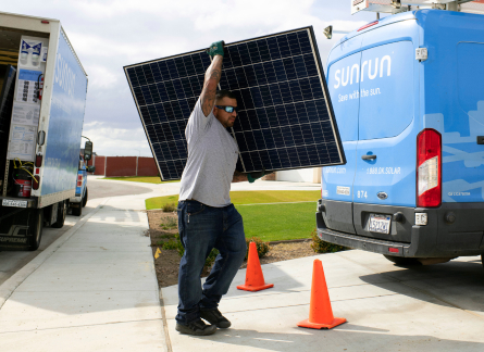 Sunrun solar installer carrying a solar panel