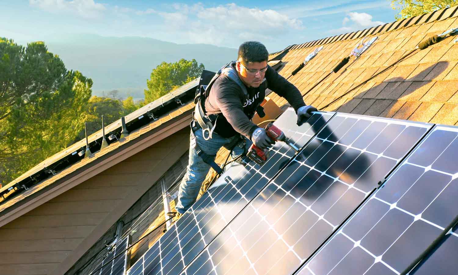 A Man Holding a Drill, Installing Solar Panels in the Roof
