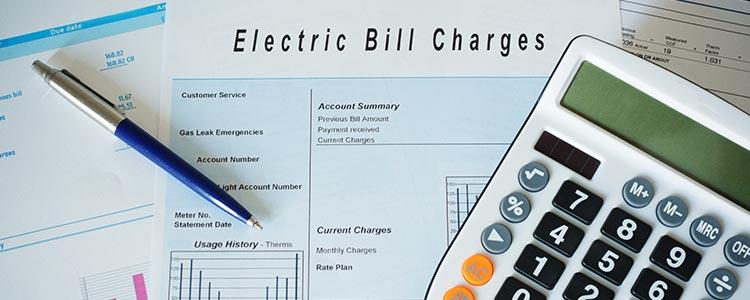 Electric Bill Charges in Paper with Calculator and Pen