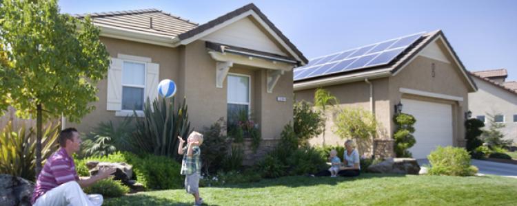 Family enjoying sports and saving on electric bill in front of a home