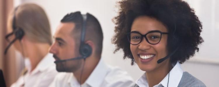 image of 3 customer service reps on the computer and phones