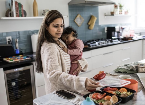 woman cooking with daughter in kitchen 